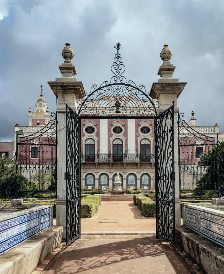 Wrought-iron gates opening onto a palace garden