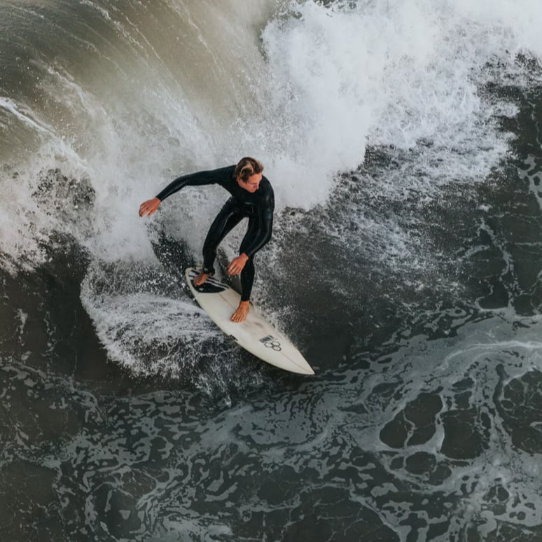 A surfer on a breaking wave, seen from above